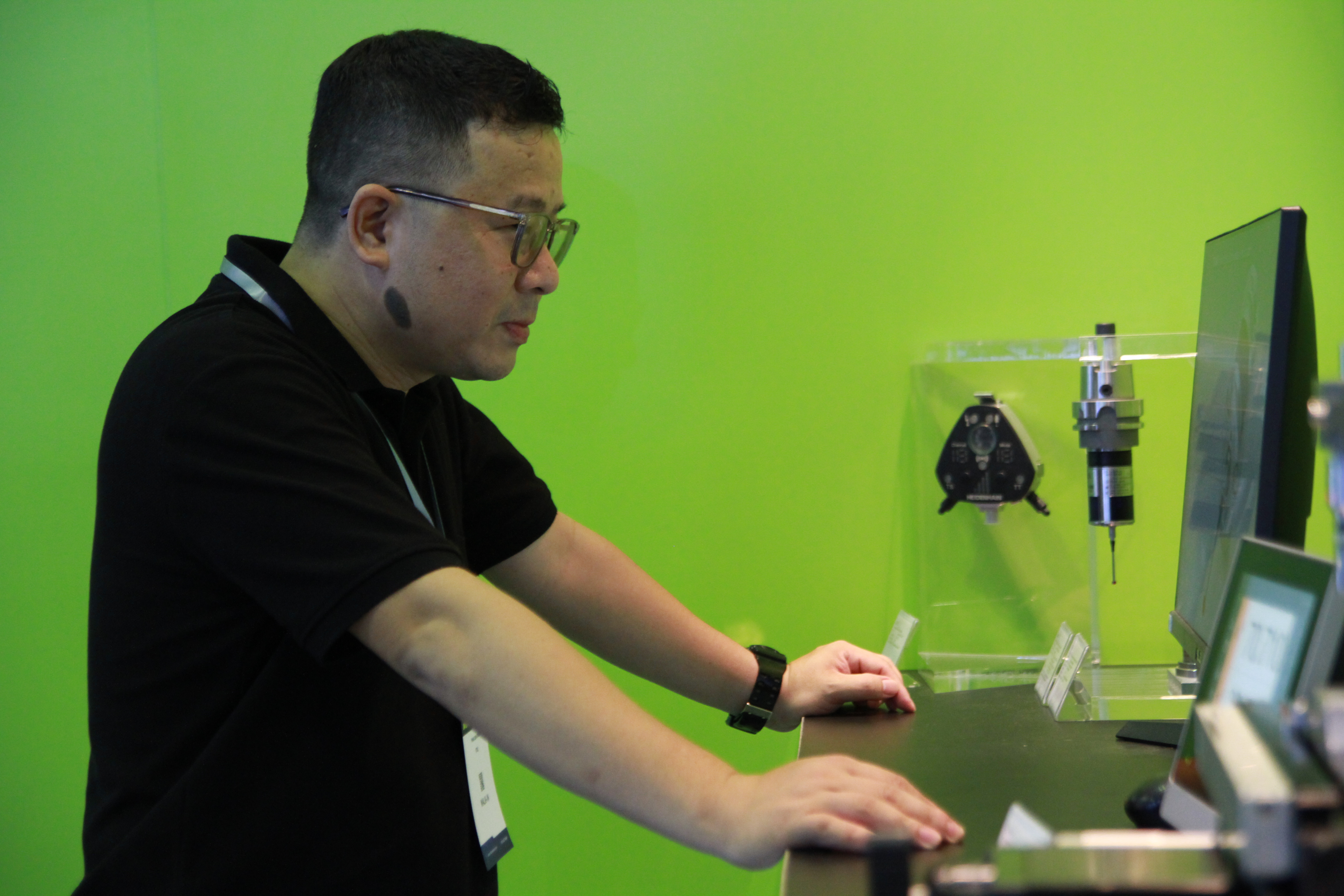 Visitor observing HEIDENHAIN products Visitor observing HEIDENHAIN products